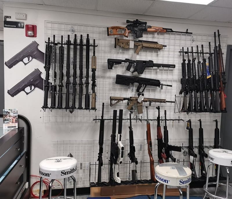 Firearm inventory wall with rifles and shotguns at Hammond Tactical gun store in Hammond, Indiana