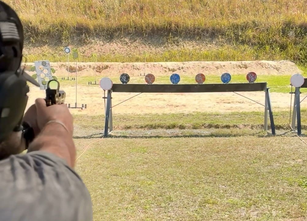 Shooter aiming a pistol at steel targets on a Northwest Indiana shooting range